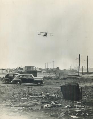 Food carrying plane is seen coming in for a landing in the strikebound Steel Company of Canada plant at Hamilton