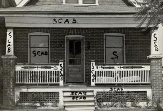Strikebreaker's house is shown smeared with the painted word scab
