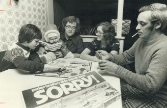 Striking paperworker Rolly Lavoie plays a game with his family, from left, Shaun, infant Tania, wife Dorothy and Joanne in their home in Iroquois Fall(...)