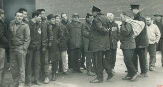 A Solid Wall of pickets at the Oshawa Times denies entry to mailing room foreman Frank Baker who arrived at the main entrance flanked by two policemen(...)