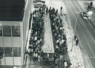 Pickets march is front of the strikebound Oshawa Times after a rally which endorsed continued defiance of an injunction limiting the number of pickets(...)