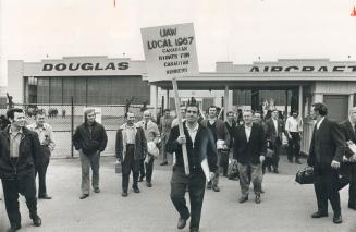Striking workers follow a picket-sign-carrying marcher as they leave the parking lot at the Malton plant of Douglas Aircraft today. The 4,500 Douglas (...)
