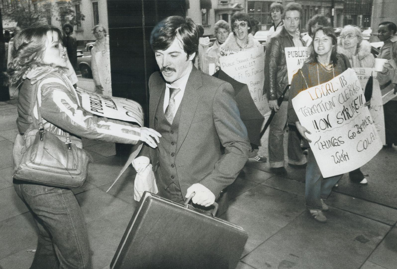 Angry strike tries to stop a worker from crossing the Public Service Alliance of Canada picket line outside the federal building on Adelaide St. today(...)