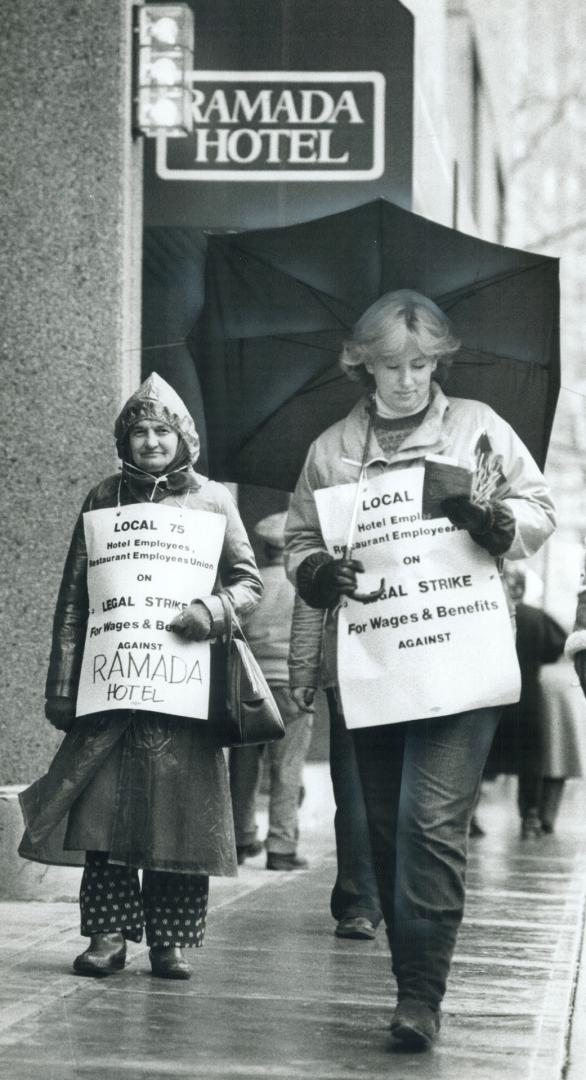 On the line: Striking front desk clerk Diane McKenzie whiles away time on the Ramada picket line by reading a book