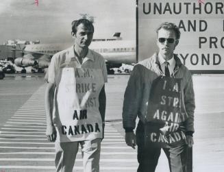 Larry Reid (left) and Norton Adderley, members of the International Association of Machinists and Aerospace Workers, walk a picket line outside the te(...)