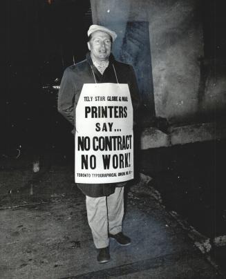 A Striking printer, sports a new placard - minus the term lockout - as he pickets The Star