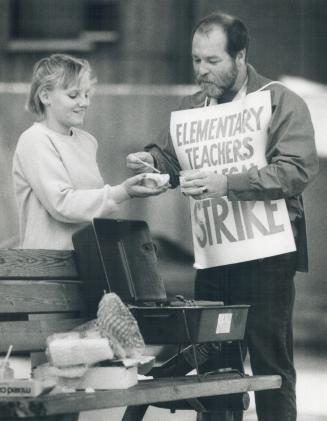 Stoking up: Don Watson, an early childhood consultant, dresses up a hot dog for Cheryl Bain, 12, on the Toronto elementary teachers picket line at Queen Alexandra Public School yesterday