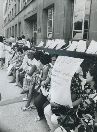 Striking workers of Toronto Western Hospital sit outside the Supreme Court of Canada on Queen St