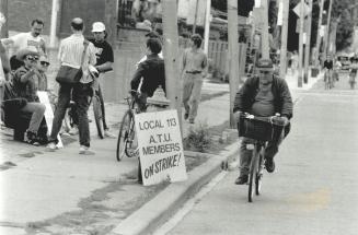 The bikes go by: striking TTC workers gather outside Connaught streetcar yards as dedicated cyclist Art Raisanen pedals by
