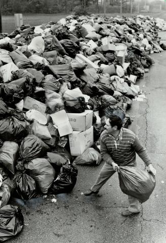 Trash mounts up: York borough resident Frank Marchese huris his garbage onto the huge mound at Keeledale Park, designated a dump site during the strike by municipal workers