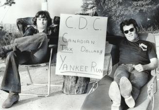 Wildcat Strikers Stan Parker and Bob Seeley relax at the entrance to the giant Polysar plant on the outskirts of Milton yesterday beside a hand-drawn (...)