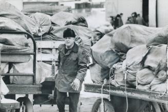 Stored MAIL is moved in the yard of the post office Terminal A and city delivery building yesterday during the 36-hour truce in the mail strike, now i(...)