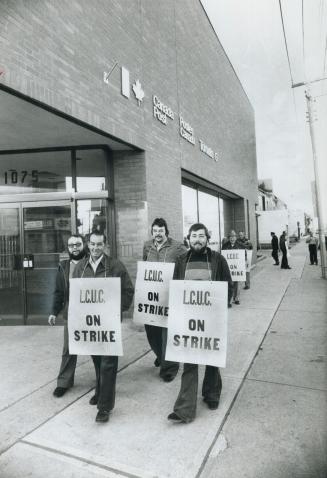 Striking letter carriers, above, picket outside postal station during recent mail strike