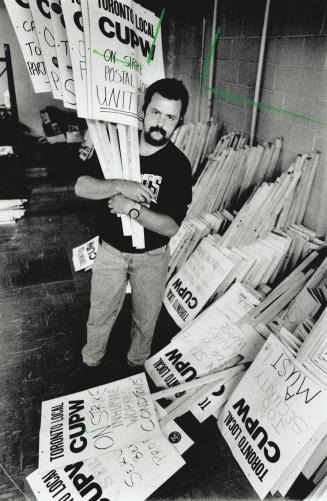 Gearing Up: Andre Kolomper, Toronto local president with the Canadian Union of Postal Workers, stacks signs last night as strike deadline approached