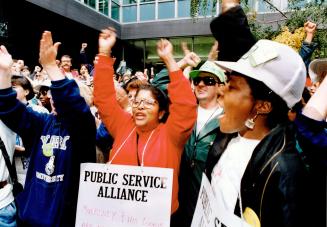 Federal civil servants raise their fists at the Revenue Canada offices on Adelaide St