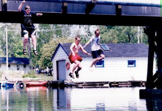 Conner Barnett, 14, left, Alex Loubert, 12, and Martin Kuryllo, 13, plunge into summer yesterday as they go for a cooling dip. They jumped off the bridge linking Algonquin and Ward's islands