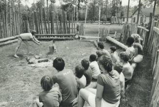 Army chores: Kids at the Salvation Army Fresh Air camp learn some of the finer points of outdoorsmanship, including how to chop wood safely, from counsellor Joe Krommenhoek, 21