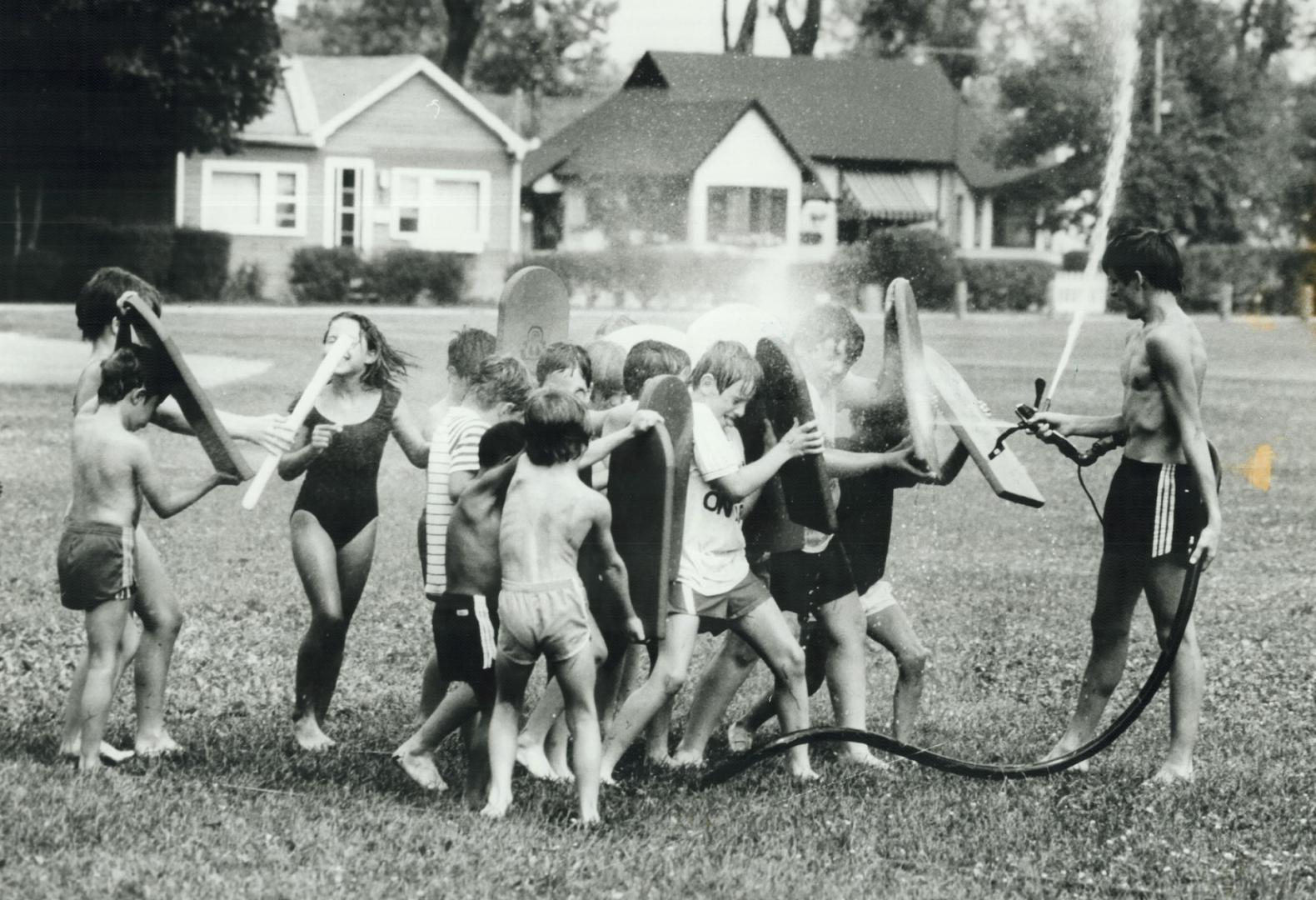 Summer camp is a blast - of cold water, Like ancient Roman legionnaires, these youngsters at the Island Canoe Camp on Toronto Islands use their paddle