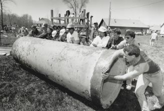 All together now: Volunteers at the Jacksons Point Camp for Kids heave into place a sewer pipe that will be used as a play tunnel