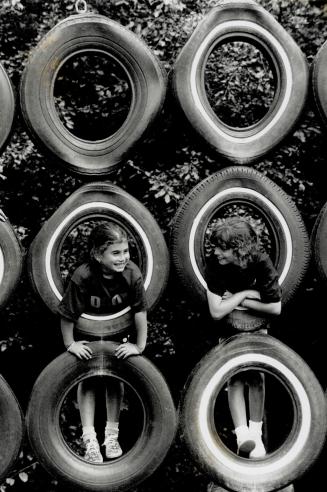 Still not Tire-D of Summer, Lana, left, and Jenna, take advantage of a spot of good eather in an otherwise chilly summer to scale a wall of tires at Forest Valley Day Camp in North York