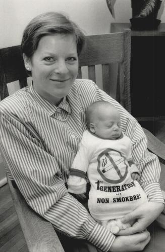 Starting 'weedless': Sam Perlmutar, 6 weeks, naps in mom Gillian Hawker's arms as he models his 1st Generation of Non-Smokers T-shirt yesterday in anticitpation of Weedless Wednesday