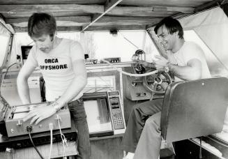 Look out below: Bob Breau (in driver's seat) looks on as partner Karl Stimpfig prepares sonar equipment