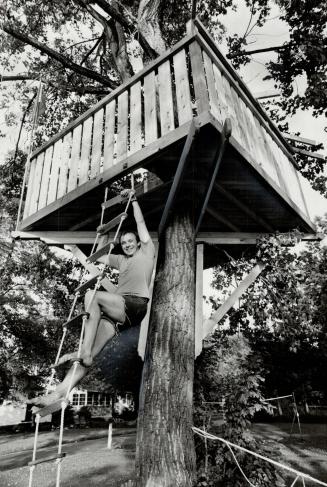 Gary Gray climbs rope lader to his son's endangered tree house on Algonquin Island