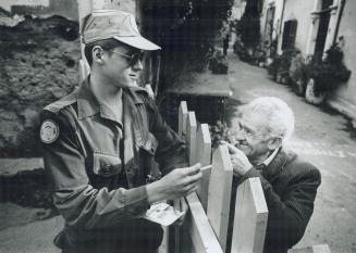 Good neighbors: Private Martin Pare offers a cigarette to a man in Nicosia, where Canadian troops have been stationed since 1964