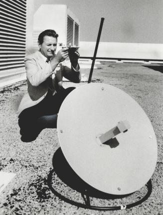 Aiming at satellites: Toronto Stock Exchange engineer Heinz Gwisdek uses a sextant to aim a satellite dish on top of The Star building at One Yonge St
