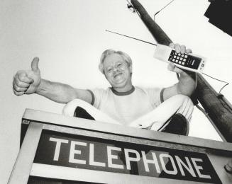 Quick communication: Tom Warner and his ultra-modern cordless phone sit atop a slightly less modern telephone booth