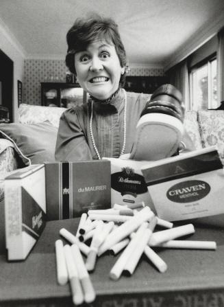 Shooing the habit, Linda Ferguson grimaces as she pulps packs of cigarettes