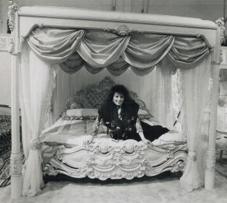 Queen for a day, Anna Arcese tries out an Italian-made, Louis XVI canopy bed at the Toronto Furniture Market