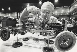 Steel wheels: Meccano-man John Worfolk of Toronto snugs up a bolt on his Mecanno car at the CNE Hobby Show yesterday