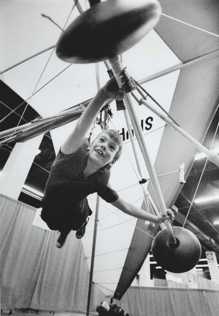 Flying high near the Airport, Ryan Copithorn, 8, tries his wings with a Wills Wing Skyhawk hang-glider at the Sports Aircraft Expo yesterday at the International Centre on Airport Rd