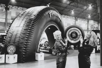 Firestone Canada hostesses hoist one of the tiemaker's products at Motorsport '90