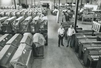 Surrounded by pianos, Len Owens, left, factory superintendent for Mason and Risch Ltd