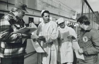 Bad news: Canada Packers workers Joe Aldridge and Bernie Dolman (in white coats) have a combined 69 years experience with the company