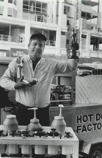 Hot dog! Vendor Thomas Manolaskos holds Oscars won by the National Film Board, which invites the public to 'get in the picture' at four locations around town today and tomorrow