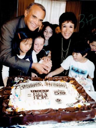 Goodwill gesture: Harry Belafonte, his wife Julie and children from Withrow Public School cut a cake yesterday to celebrate 50 years of UNICEF