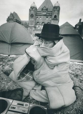 Cold day at peace camp, Ian McDougall huddles in a sleeping bag on the front lawn of Queen's Park yesterday
