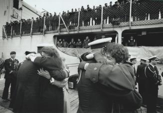 Return to arms: Canadian navy officers rush into the embrace of loved ones on dockside at Halifax after 7 1/2 months in the gulf