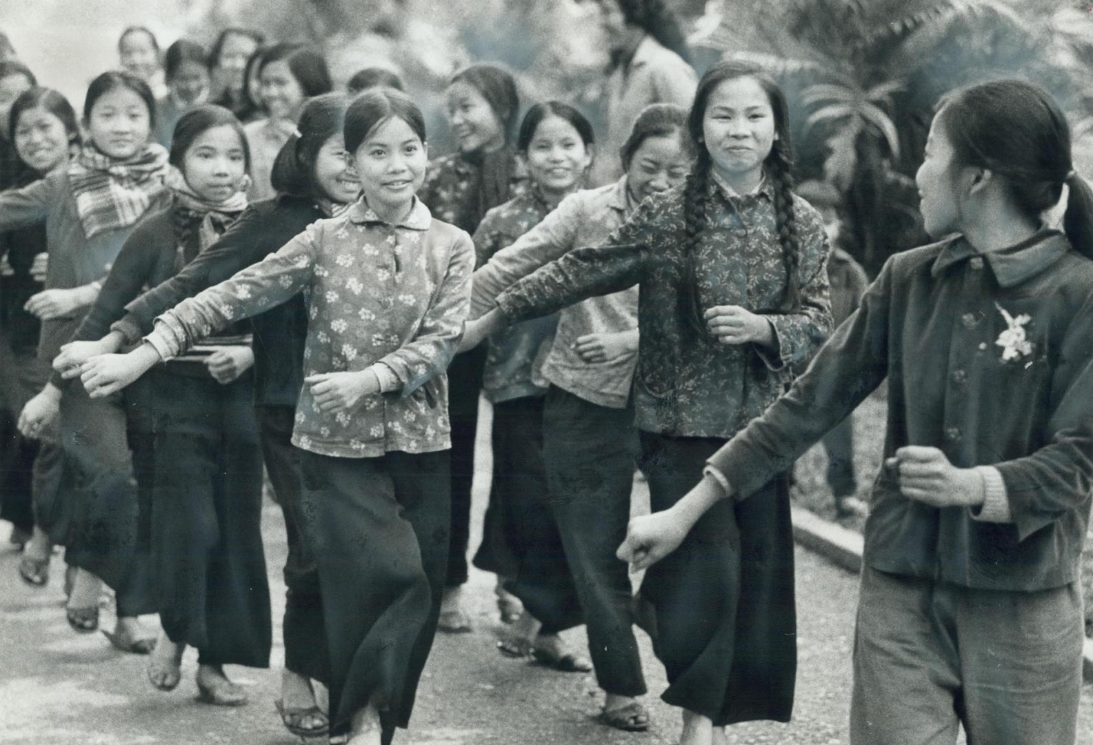 Smiling girls march in one of the many green parks of Hanoi, practising for the big parade on May Day, the world-wide Communist holiday. Some of the b(...)