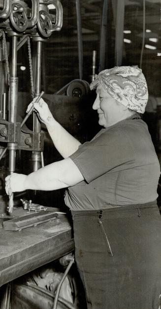 Grandmother Mary Beer can handle any one of a dozen machines at the war plant where she is employed