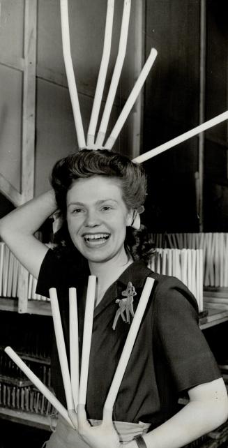 These Tubes of waste paper, held by Joyce Winn, are vital components of anti-aircraft shells