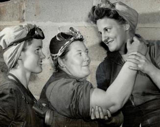 That's all muscle on the arm of Mrs. Robert Wright, 235-pound sandblaster at John Inglis Co. in Toronto. Mrs. Mollie Robinson feels the muscle, while (...)
