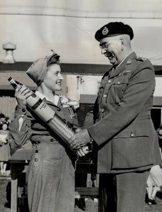Mrs. V. Coole presents shell to col. Smith, Ajax. Sept. 11- Several thousand shell-fillers from the Ajax plant saw the 25 millionth shell to roll off (...)