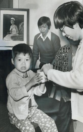 Getting her first taste of Canadian life, 4-year-old Nguyen Quynh Mai takes a glass of pop from her uncle, Nguyen-Huu Hoi of Bathurst St., while her b(...)