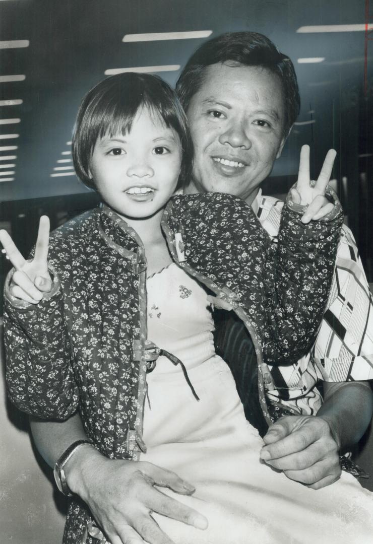 Lee Khanh Nhieu, 6, makes victory sign as she arrives in Metro with dad