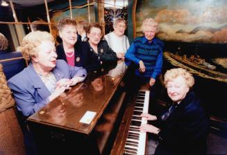 War reunion: Former navy nurse Florence Parrott plays piano for ex-Wrens, from left, Jean Brodie, Madeleine Carter, Lil Roe, Gertrude Grich and Evelyn Oldham