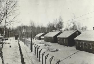 Nestled in snow, Double wire fencing features the camp-like atmosphere of the internment centre at Petawawa